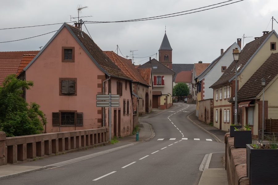 Straßenansicht im Dorfzentrum von Dossenheim-sur-Zinsel mit der Kirche Saint-Léonard
