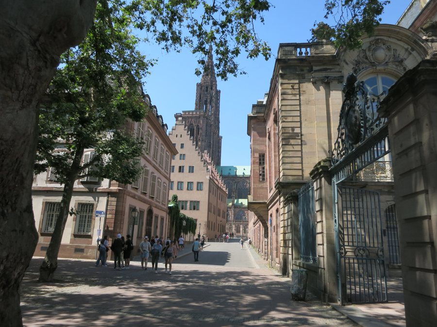 Historische Gasse in Straßburg mit Blick auf das gotische Münster und Fußgängern.